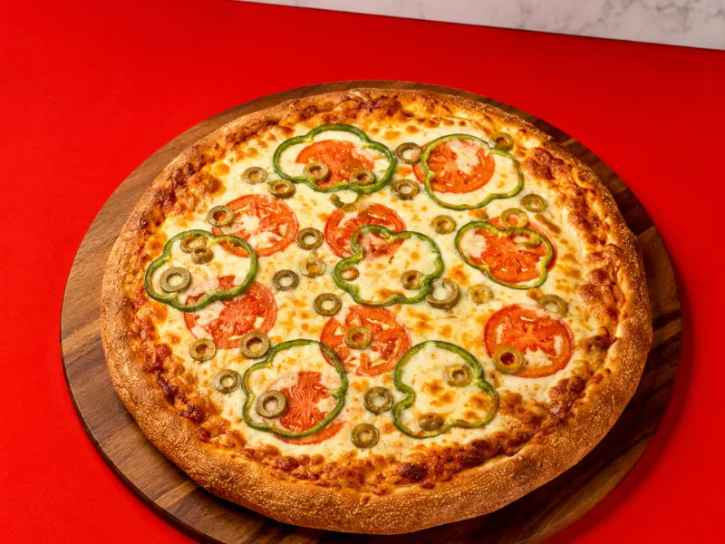 A pizza topped with tomatoes, green peppers and jalapenos